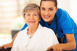 Senior woman on wheelchair with caregiver