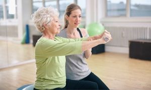 Senior woman training in the gym with a personal trainer