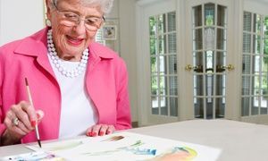 Elderly woman painting with watercolors